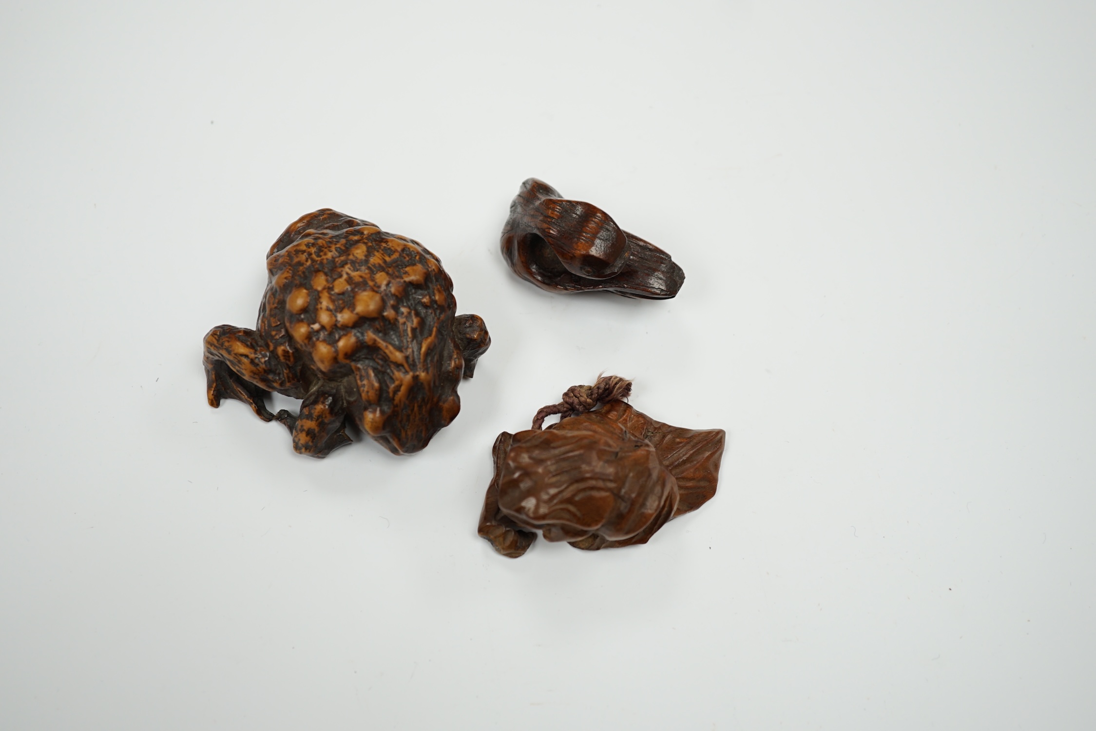 Three Japanese hardwood netsukes in the form of frogs and a swan, largest 5.5cm in length